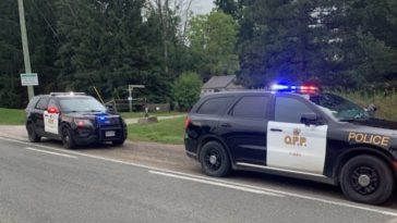 Two police vehicles on the side of a road.