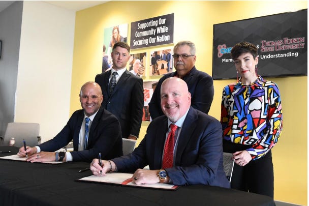 Thomas Edison State University representative Thomas Phillips (front row, from left) and Pantex Deputy Site Manager Kenny Steward sign a memorandum of understanding that offers Pantex employees deferred tuition and a reduced tuition rate for the school’s online programs. Looking on are (back row, from left) Pantex employee Justin Fox, Carlos Alvorado of the National Nuclear Safety Administration Production Office and Pantex employee Shelbi Gray.