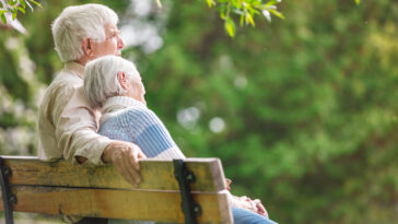 Elderly couple resting on a bench in the park